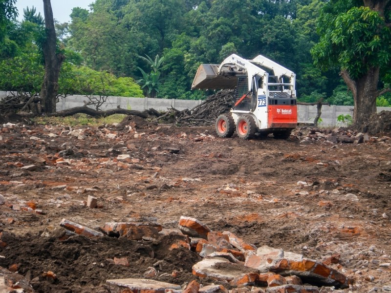 Minicargador Bobcat limpiando un terreno con ripio